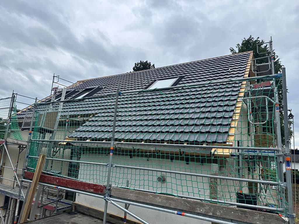 Neu eingedecktes Dach mit integrierten Dachfenstern. Neu eingedecktes Dach mit integrierten Dachfenstern während einer Dachsanierung zur energetischen Modernisierung eines Wohngebäudes.