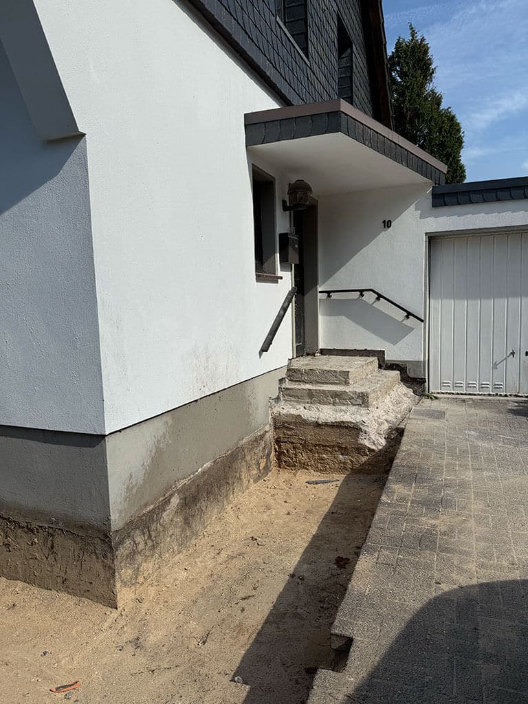 Freilegung der Kellerwand zur Vorbereitung der Abdichtungs- und Sanierungsarbeiten. Freilegung des Gebäudesockels zur Vorbereitung der Kellerabdichtung im Zuge der Kernsanierung eines Wohngebäudes in Langenfeld.