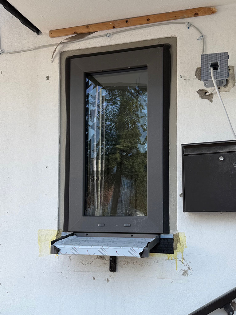 Modernisierung der Gebäudehülle durch den Einbau energieeffizienter Fensterelemente. Einbau eines neuen energieeffizienten Fensters im Eingangsbereich eines Wohngebäudes im Zuge der Kernsanierung in Langenfeld.