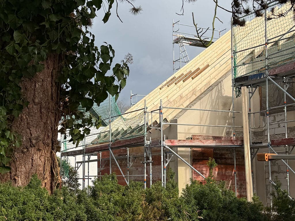 Einbau neuer Dachbalken im Rahmen der Dachsanierung. Neue Dachbalken im Zuge einer Dachsanierung auf einem Bestandsgebäude als Vorbereitung für die weitere Dachmodernisierung.