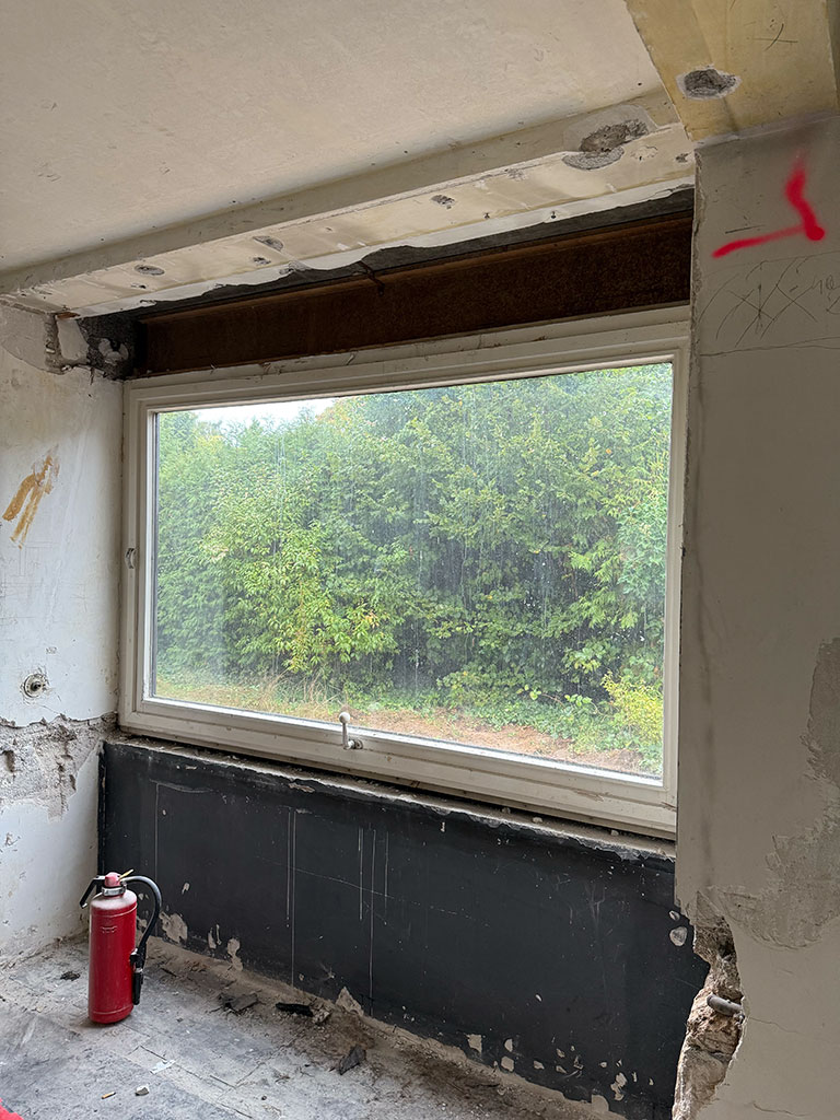 Altes Fenster vor dem Austausch. Fensteraustausch während der Kernsanierung eines Wohngebäudes in Köln-Rath zur Vorbereitung größerer Fensterflächen.