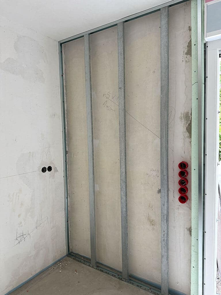 Trockenbau und Vorbereitung der Elektroinstallation für die spätere Wandverkleidung. Metallständerwerk im Trockenbau während einer Innenraumsanierung mit vorbereiteten Unterputzdosen für die Elektroinstallation.